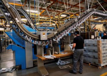 Men wearing protective face masks work at a printing press amid the coronavirus disease (COVID-19) outbreak in Madrid, Spain, June 13, 2020.