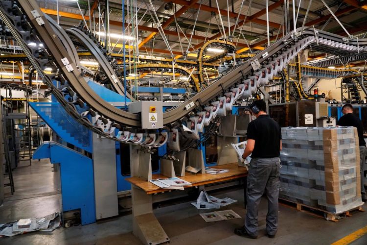 Men wearing protective face masks work at a printing press amid the coronavirus disease (COVID-19) outbreak in Madrid, Spain, June 13, 2020.